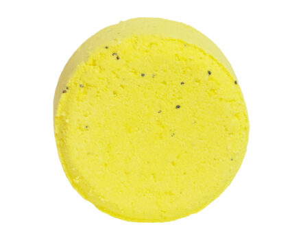 Bright yellow bath bomb with black specks of poppy seed, set against a white background