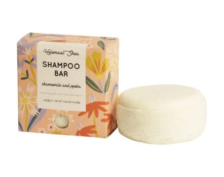 Perzikkleurige kartonnen doos voor parfumvrije kamille- en jojoba-olie shampoo bar. De witte shampoo bar ligt naast het doosje.