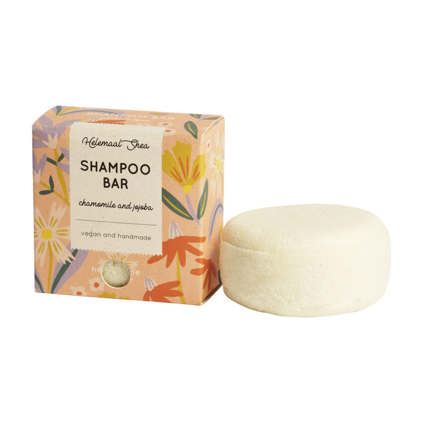 peach cardboard box for perfume free chamomile and jojoba oil shampoo bar. white shampoo bar is sitting next to box