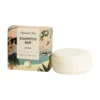 Light colored cardboard box next to white coconut shampoo bar from HelemaalShea