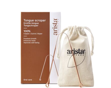 Copper tongue scraper Infront of beigne cotton storage bag and brown and white cardboard packaging